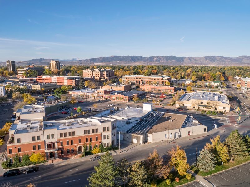 Aerial view of homes and shops with the foothills beyond in Fort Collins