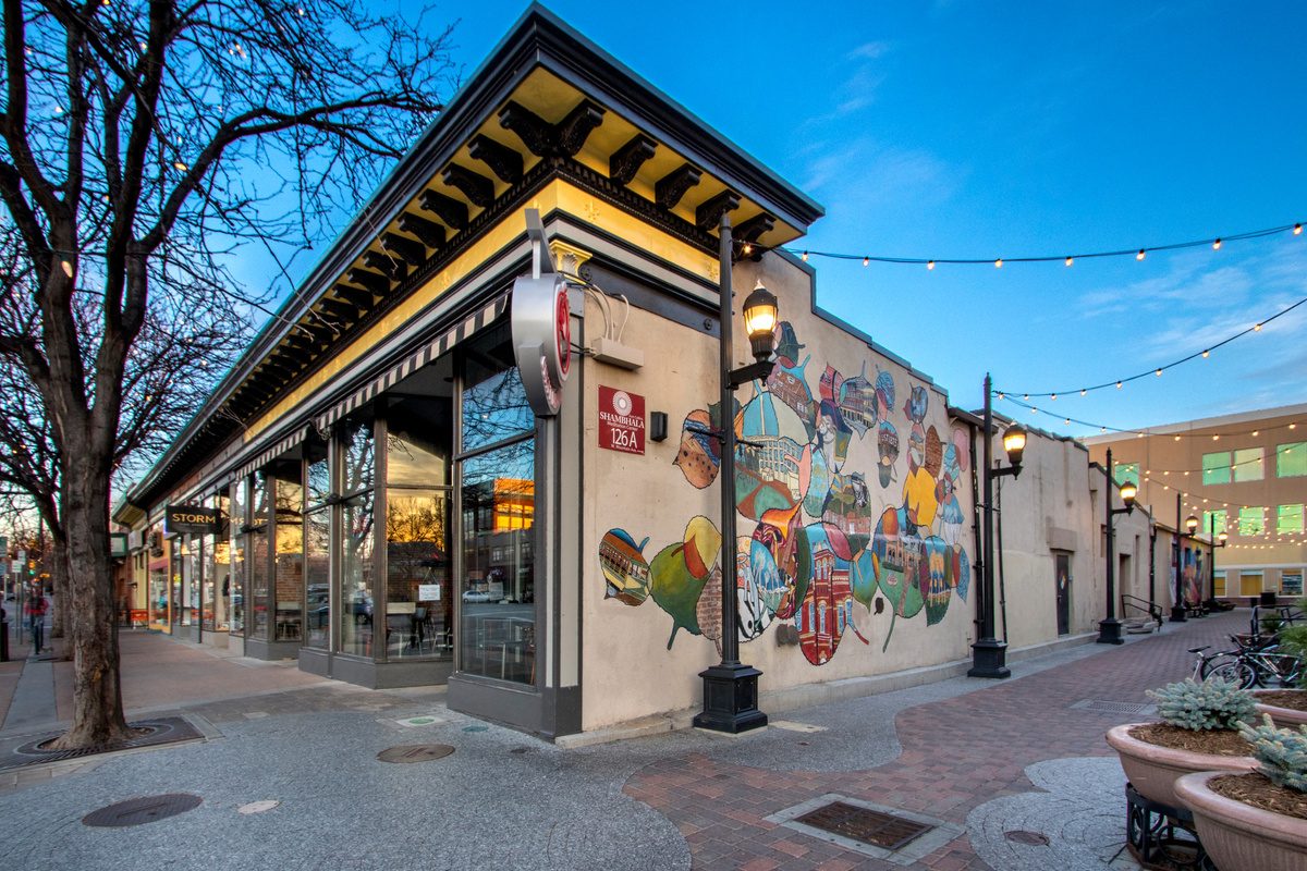 Shops and a colorful mural on a brick street in Old Town Fort Collins
