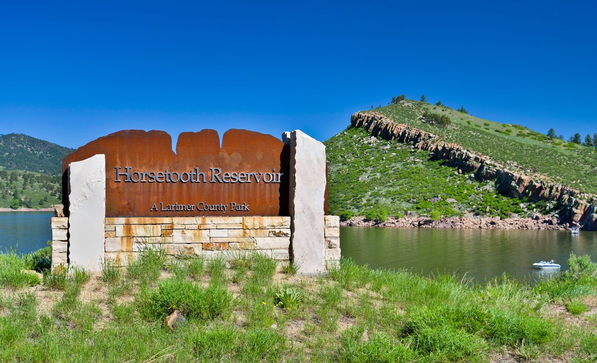 Horsetooth Reservoir sign with the foothills behind it, west of Fort Collins